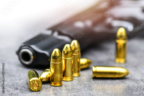 Gun with ammunition on stone background. 9 mm pistol gun weapon and bullets at table.