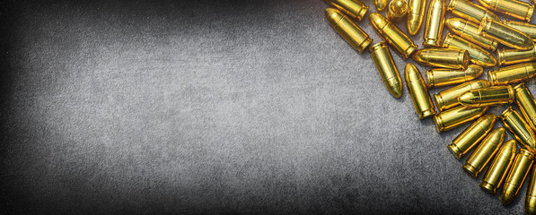 Bullets ammunition on stone table wide banner or panorama. Bullet pile background copy space.  Ammo military technology. Copy space for text photo cocept.