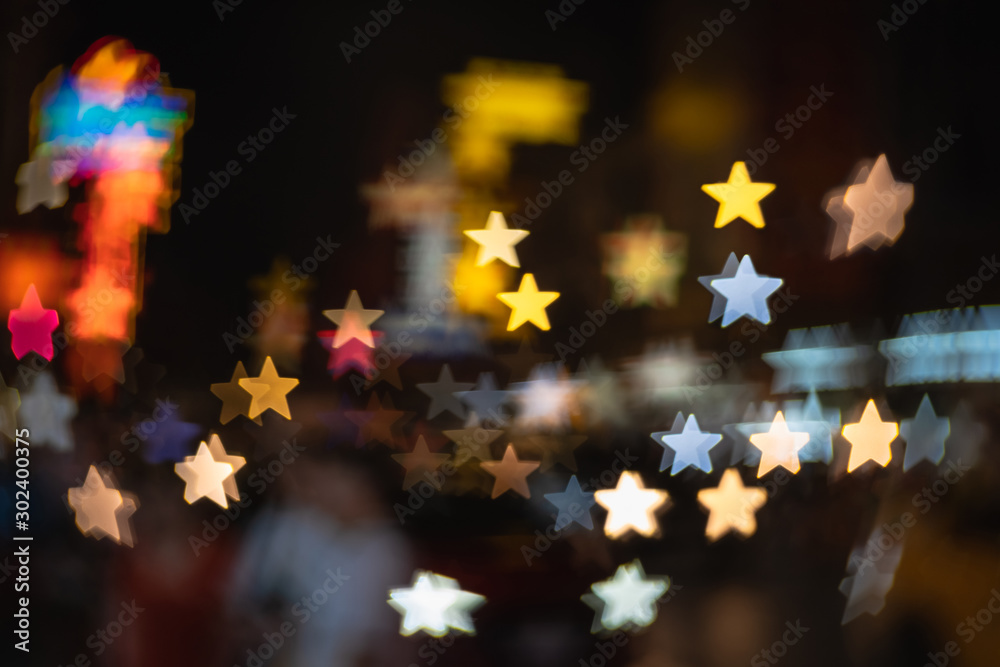 Defocused in city night street colorful rays lights with star bokeh background, Blurred dramatic glowing night lights, Abstract magic background for festive celebrate holiday new year banner concept