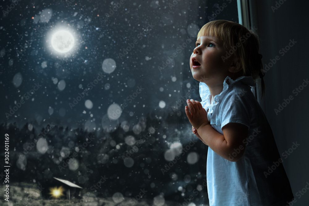 child looks out the window on Christmas day child looks out the window on Christmas day