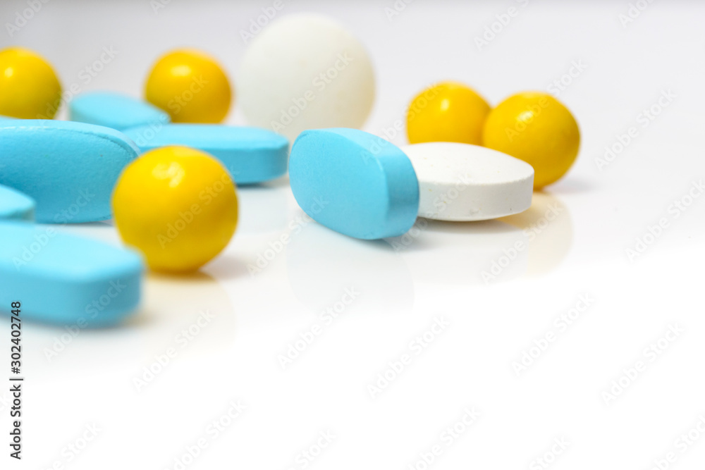 blue, yellow pills on a white background close-up