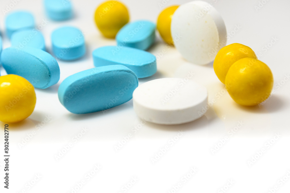 blue, yellow pills on a white background close-up