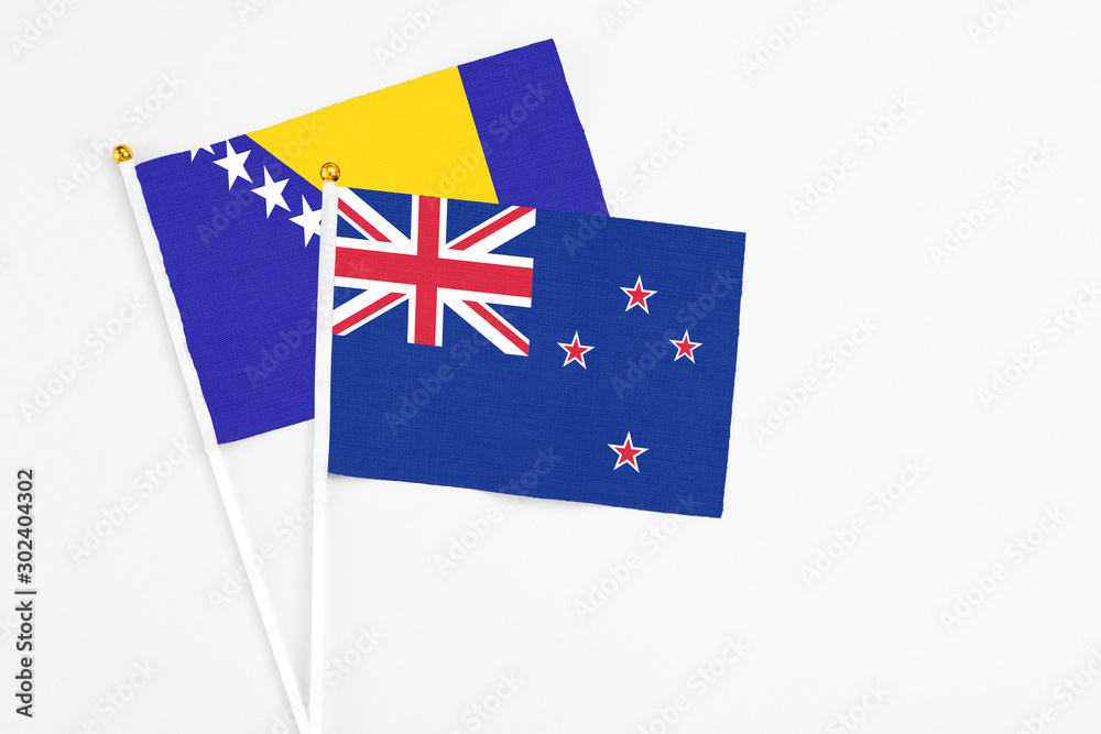 Fototapeta premium New Zealand and Bosnia Herzegovina stick flags on white background. High quality fabric, miniature national flag. Peaceful global concept.White floor for copy space.