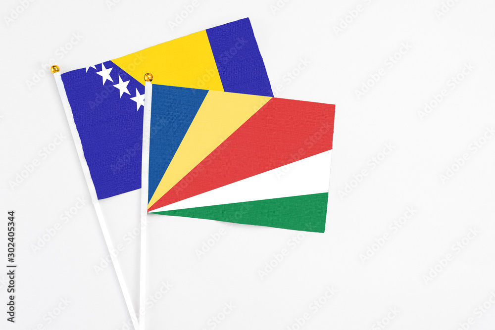 Seychelles and Bosnia Herzegovina stick flags on white background. High quality fabric, miniature national flag. Peaceful global concept.White floor for copy space.
