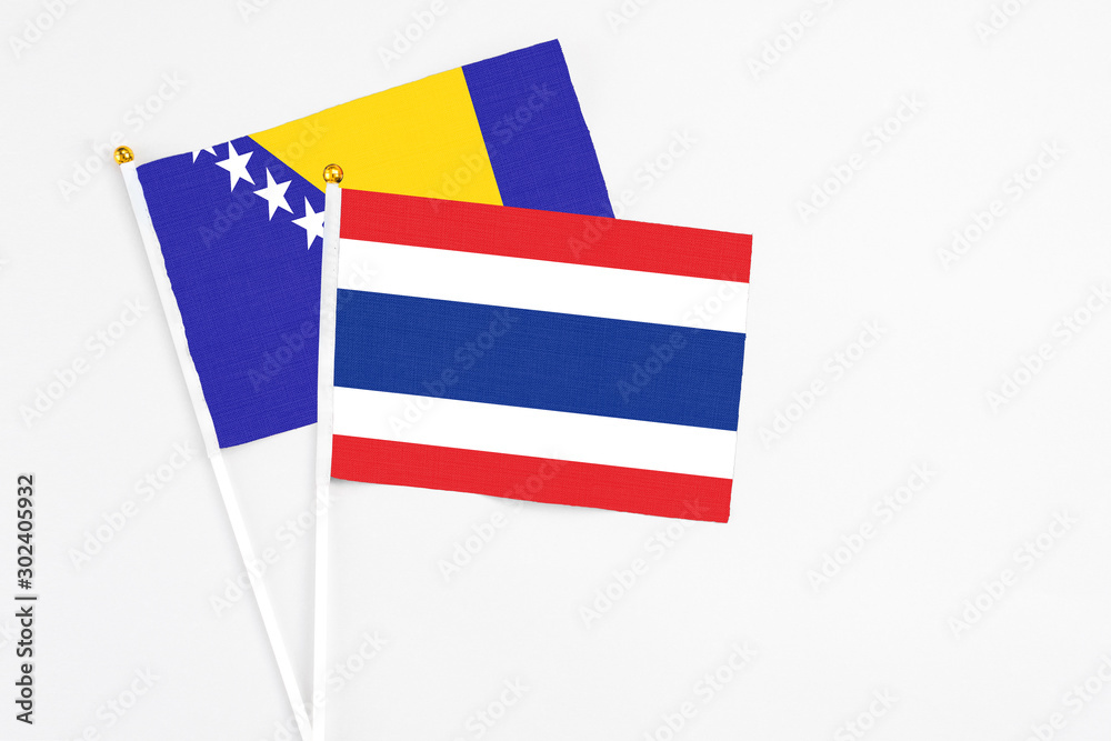 Obraz premium Thailand and Bosnia Herzegovina stick flags on white background. High quality fabric, miniature national flag. Peaceful global concept.White floor for copy space.