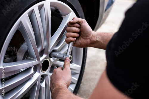 Picture of a man changing tires on the car