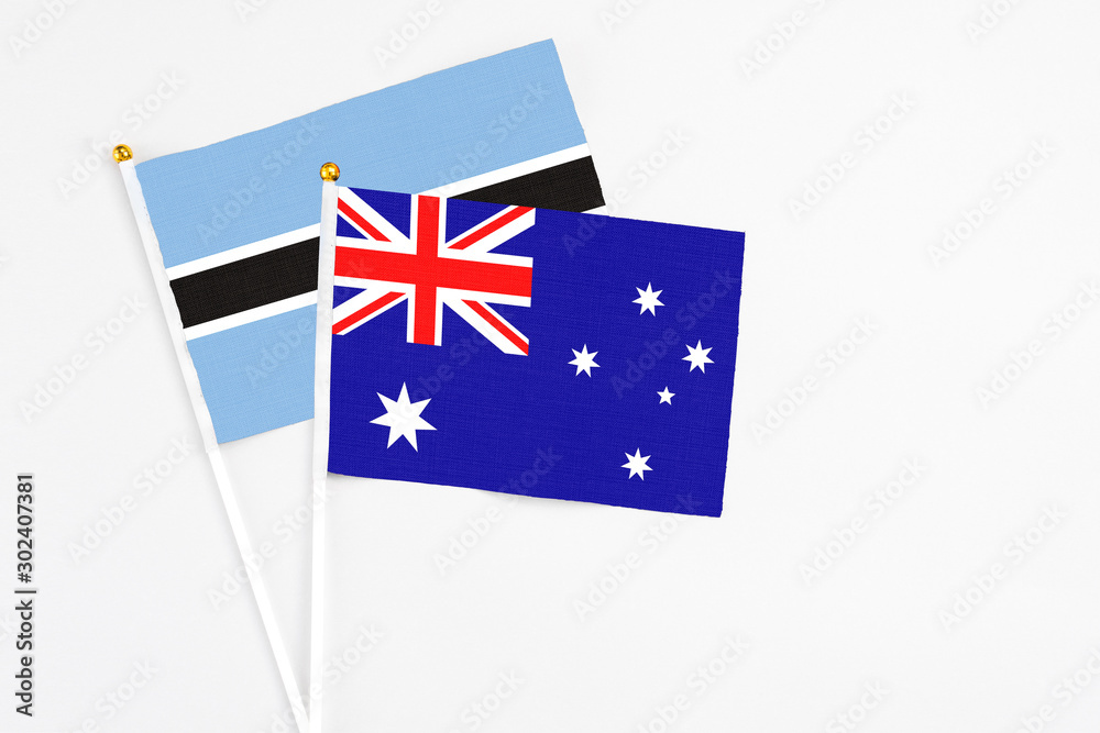 Fototapeta premium Australia and Botswana stick flags on white background. High quality fabric, miniature national flag. Peaceful global concept.White floor for copy space.