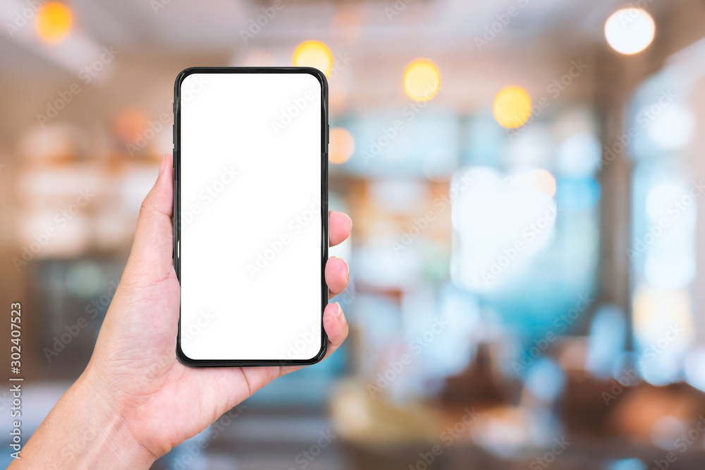 Hand holding smartphone with abstract blur shopping mall background ...