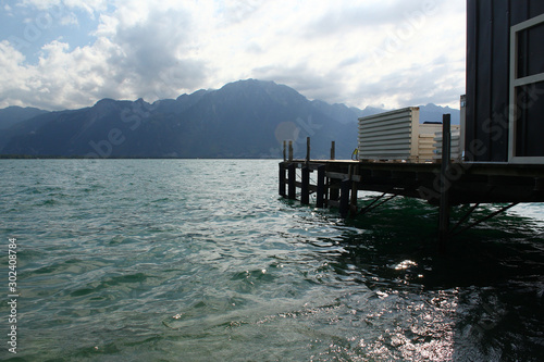 A wooden pier at a big lake with view on mountains. Location: Lake Geneva, Montreux, Switzerland
