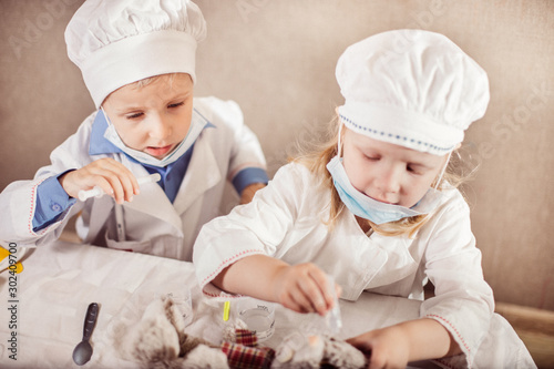little children enthusiastically play doctors and treat toys