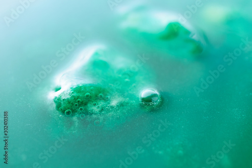 Vibrant green glue slime abstract background with selective focus. Concept water pollution, environmental protection