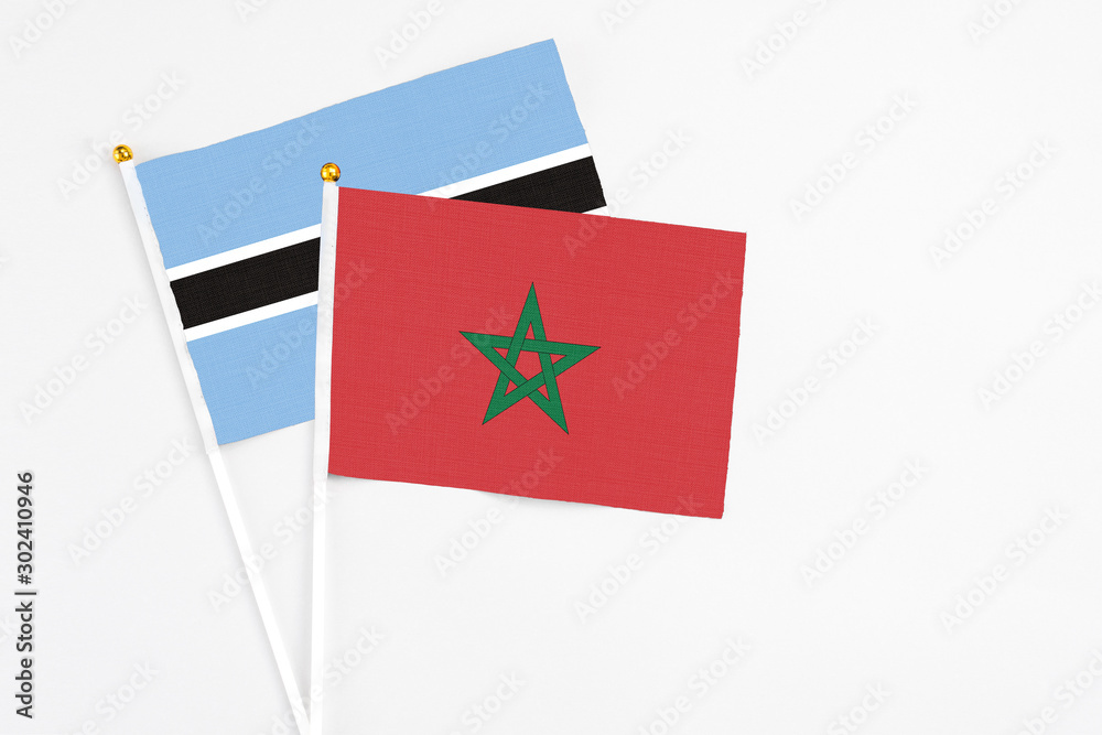 Morocco and Botswana stick flags on white background. High quality fabric, miniature national flag. Peaceful global concept.White floor for copy space. Morocco and Botswana stick flags on white background. High quality fabric, miniature national flag. Peaceful global concept.White floor for copy space.