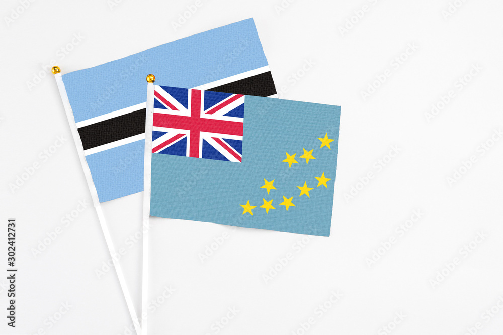 Tuvalu and Botswana stick flags on white background. High quality fabric, miniature national flag. Peaceful global concept.White floor for copy space. Tuvalu and Botswana stick flags on white background. High quality fabric, miniature national flag. Peaceful global concept.White floor for copy space.