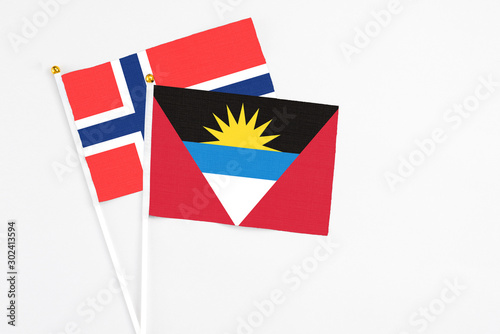 Antigua and Barbuda and Bouvet Islands stick flags on white background. High quality fabric, miniature national flag. Peaceful global concept.White floor for copy space. photo