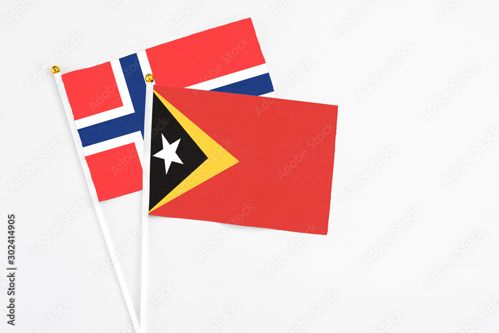 East Timor and Bouvet Islands stick flags on white background. High quality fabric, miniature national flag. Peaceful global concept.White floor for copy space. East Timor and Bouvet Islands stick flags on white background. High quality fabric, miniature national flag. Peaceful global concept.White floor for copy space.