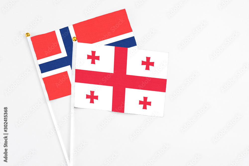 Georgia and Bouvet Islands stick flags on white background. High quality fabric, miniature national flag. Peaceful global concept.White floor for copy space.