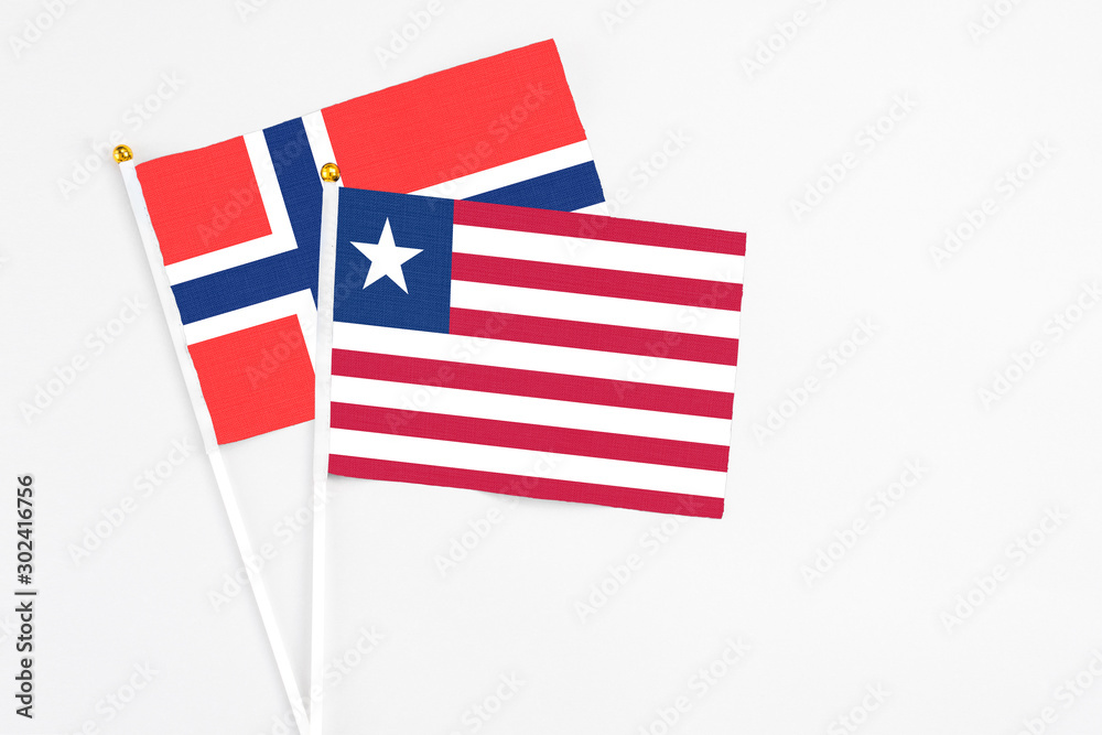 Liberia and Bouvet Islands stick flags on white background. High quality fabric, miniature national flag. Peaceful global concept.White floor for copy space. Liberia and Bouvet Islands stick flags on white background. High quality fabric, miniature national flag. Peaceful global concept.White floor for copy space.