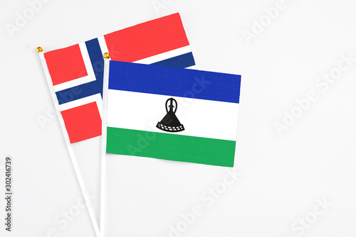 Lesotho and Bouvet Islands stick flags on white background. High quality fabric, miniature national flag. Peaceful global concept.White floor for copy space. photo