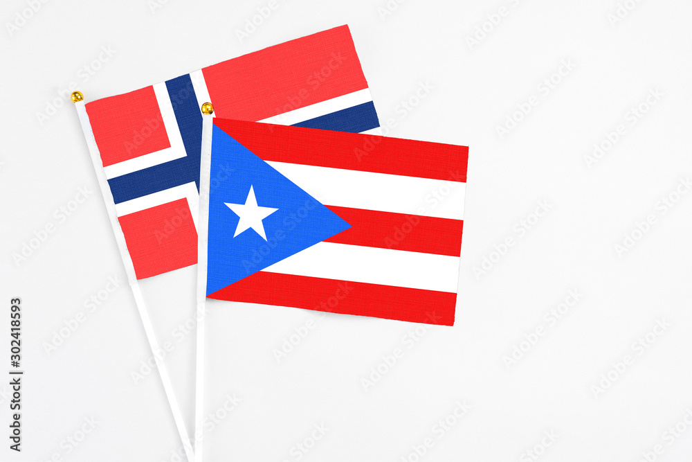 Puerto Rico and Bouvet Islands stick flags on white background. High quality fabric, miniature national flag. Peaceful global concept.White floor for copy space. Puerto Rico and Bouvet Islands stick flags on white background. High quality fabric, miniature national flag. Peaceful global concept.White floor for copy space.