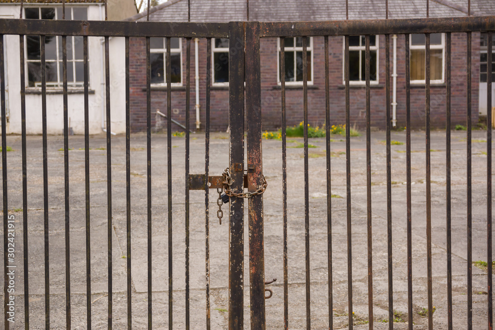 Set of locked security gates at a derelict or abandoned industrial or commercial premises Set of locked security gates at a derelict or abandoned industrial or commercial premises
