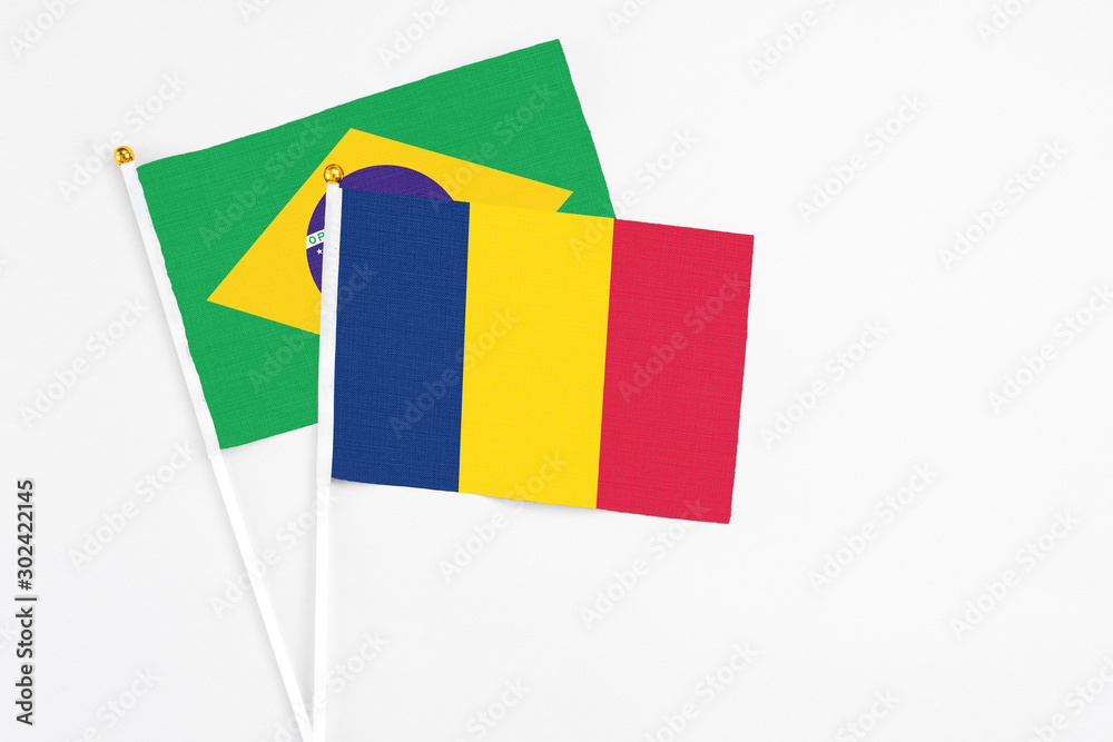 Chad and Brazil stick flags on white background. High quality fabric, miniature national flag. Peaceful global concept.White floor for copy space.