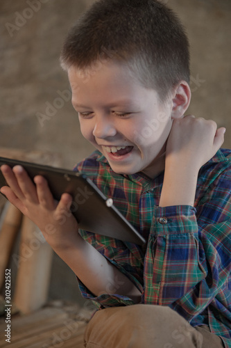 Child in bright clothes are playing on tablet computer