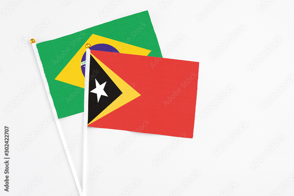 East Timor and Brazil stick flags on white background. High quality fabric, miniature national flag. Peaceful global concept.White floor for copy space. East Timor and Brazil stick flags on white background. High quality fabric, miniature national flag. Peaceful global concept.White floor for copy space.