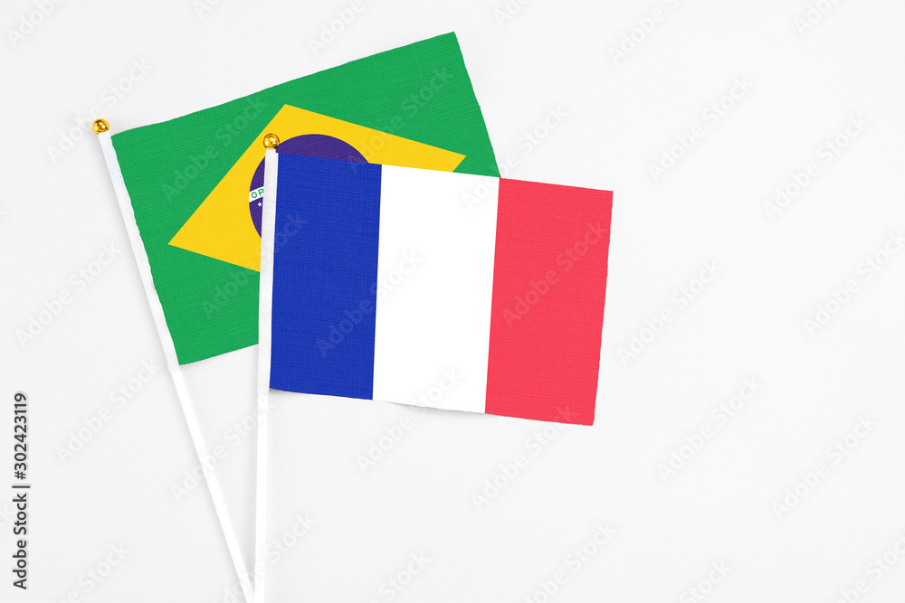 France and Brazil stick flags on white background. High quality fabric, miniature national flag. Peaceful global concept.White floor for copy space. France and Brazil stick flags on white background. High quality fabric, miniature national flag. Peaceful global concept.White floor for copy space.