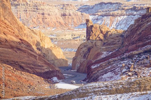 AERIAL  White lorry drives along an asphalt road winding through the canyon