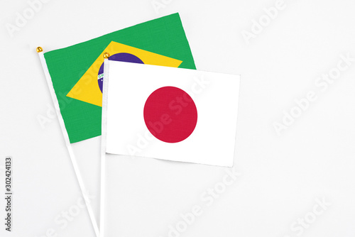 Free Download Japan and Brazil stick flags on white background. High quality fabric, miniature national flag. Peaceful global concept.White floor for copy space. - GFXLoad