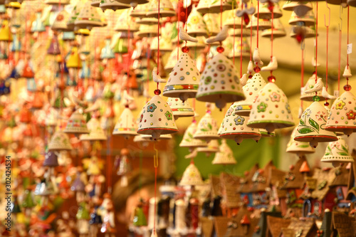 Florence, ITALY - DECEMBER 2018: small decorated bells hanging from the roof at the Christmas market in front of the 'Basilica of Santa Croce'. Christmas