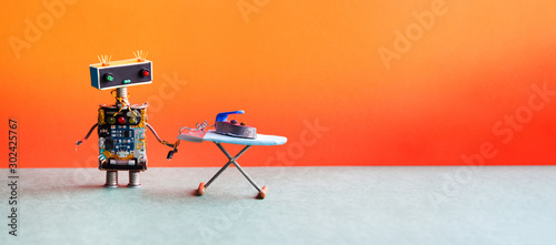 Comical robotic art. Funny domestic robot housework assistant with steam iron on the board. Orange wall room interior. copy space photo