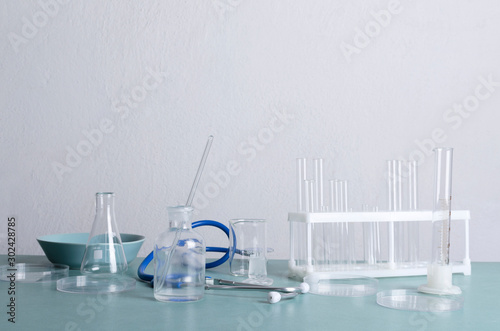 Laboratory equipmant for medical research.Glassware on the blue lab table against white wall.Empty space for text photo