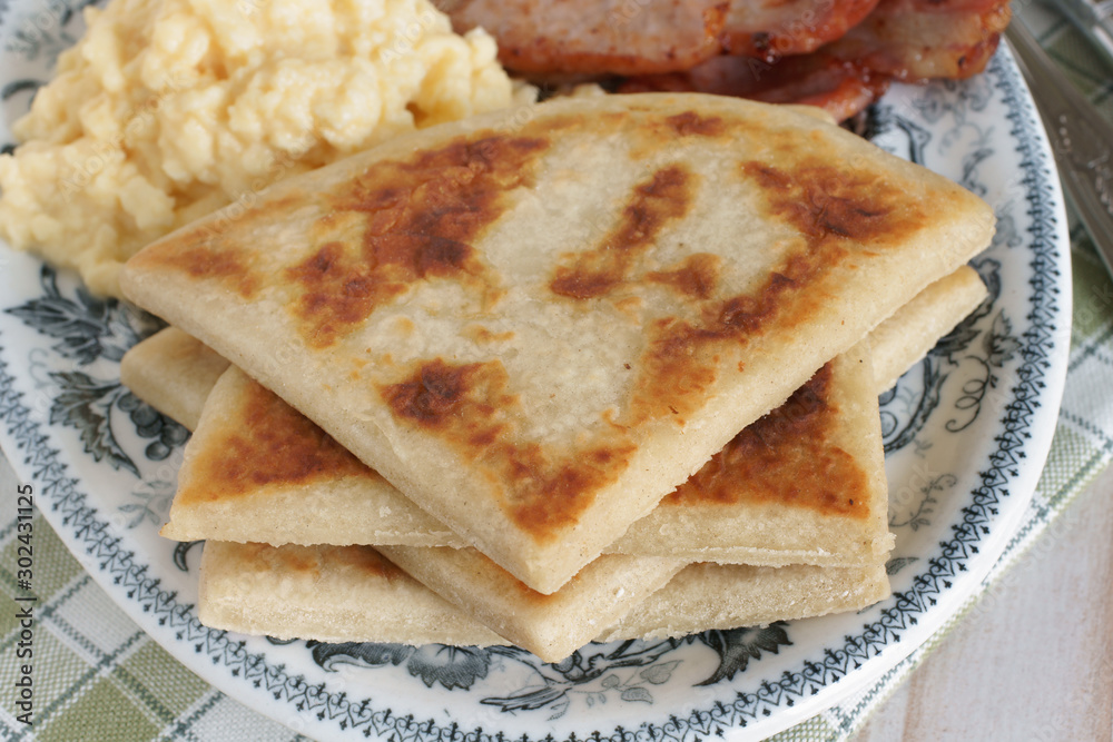 Irish potato farls or potato cakes with bacon and scrambled eggs Irish potato farls or potato cakes with bacon and scrambled eggs