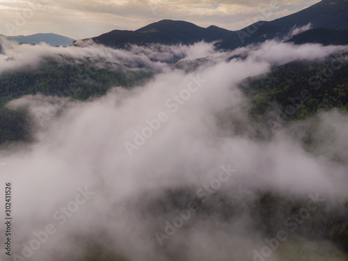 aerial view over clouds in forest landscape rain