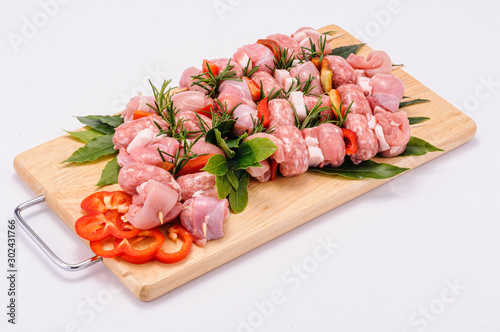 Spiedini di carne di maiale su tagliere di legno photo