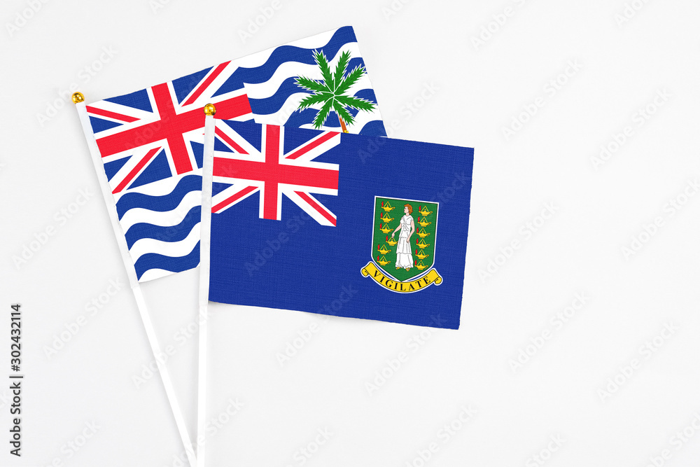 Fototapeta premium British Virgin Islands and British Indian Ocean Territory stick flags on white background. High quality fabric, miniature national flag. Peaceful global concept.White floor for copy space.