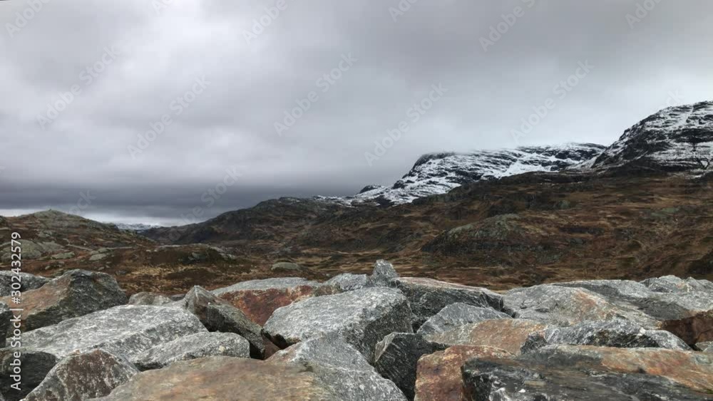 Mountain ridge with snowy mountain tops and rocks in the foreground. Clouds and weather. Still footage. Mountain ridge with snowy mountain tops and rocks in the foreground. Clouds and weather. Still footage.
