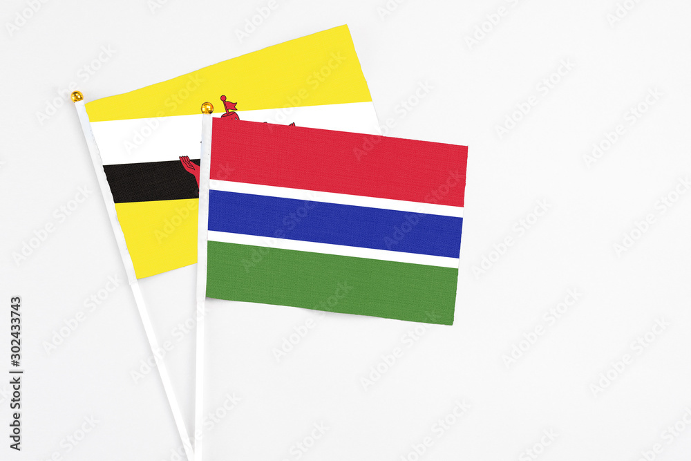 Gambia and Brunei stick flags on white background. High quality fabric, miniature national flag. Peaceful global concept.White floor for copy space. Gambia and Brunei stick flags on white background. High quality fabric, miniature national flag. Peaceful global concept.White floor for copy space.