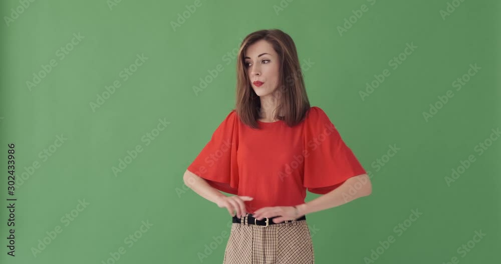 Young impatient woman waiting and checking time over green background Young impatient woman waiting and checking time over green background