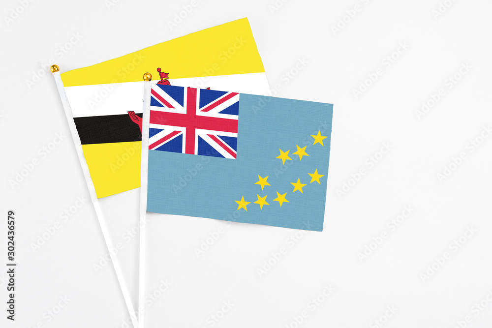 Tuvalu and Brunei stick flags on white background. High quality fabric, miniature national flag. Peaceful global concept.White floor for copy space. Tuvalu and Brunei stick flags on white background. High quality fabric, miniature national flag. Peaceful global concept.White floor for copy space.