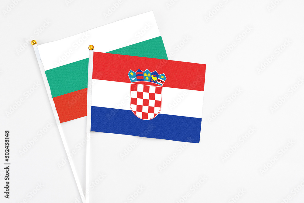 Naklejka premium Croatia and Bulgaria stick flags on white background. High quality fabric, miniature national flag. Peaceful global concept.White floor for copy space.