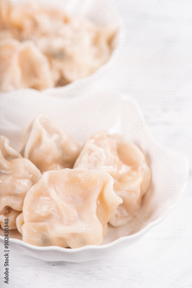 Fresh, delicious boiled pork, shrimp gyoza dumplings on white background with soy sauce and chopsticks, close up, lifestyle. Homemade design concept. Fresh, delicious boiled pork, shrimp gyoza dumplings on white background with soy sauce and chopsticks, close up, lifestyle. Homemade design concept.