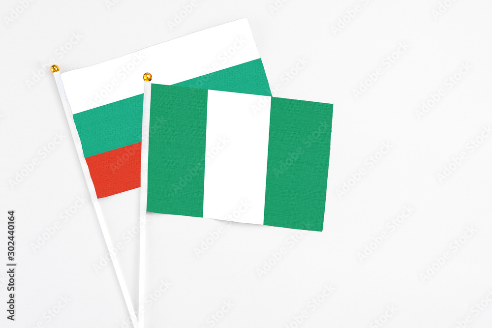 Nigeria and Bulgaria stick flags on white background. High quality fabric, miniature national flag. Peaceful global concept.White floor for copy space. Nigeria and Bulgaria stick flags on white background. High quality fabric, miniature national flag. Peaceful global concept.White floor for copy space.