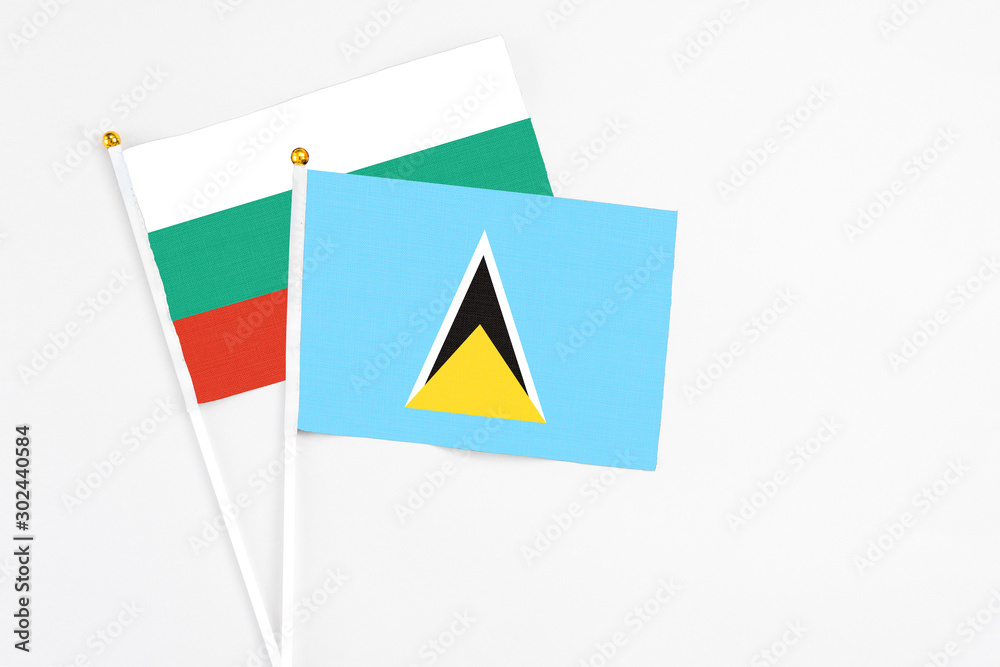 Saint Lucia and Bulgaria stick flags on white background. High quality fabric, miniature national flag. Peaceful global concept.White floor for copy space.