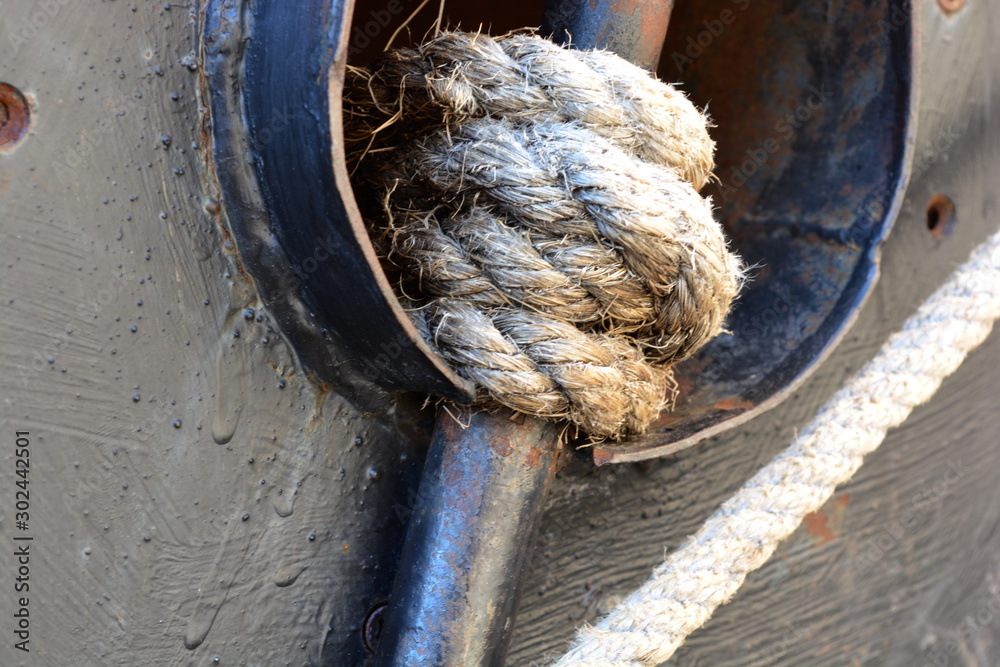 Large thick, strong, marine rope tied in a knot in marina Stock