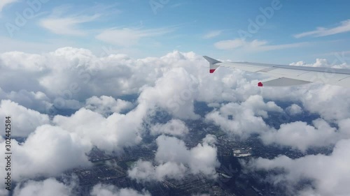 London, UK - August 2019: Wing of an airplane flying above clouds and then entering a cloud