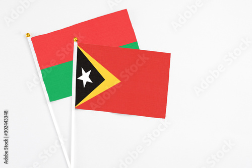 Free Download East Timor and Burkina Faso stick flags on white background. High quality fabric, miniature national flag. Peaceful global concept.White floor for copy space. - GFXLoad
