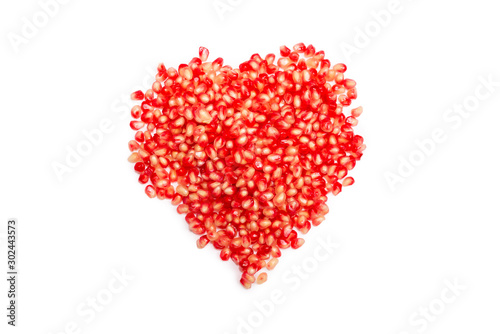 Pomegranate seeds isolated on white. Heart symbol.