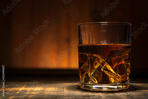 glass of whiskey on a wooden table in a bar